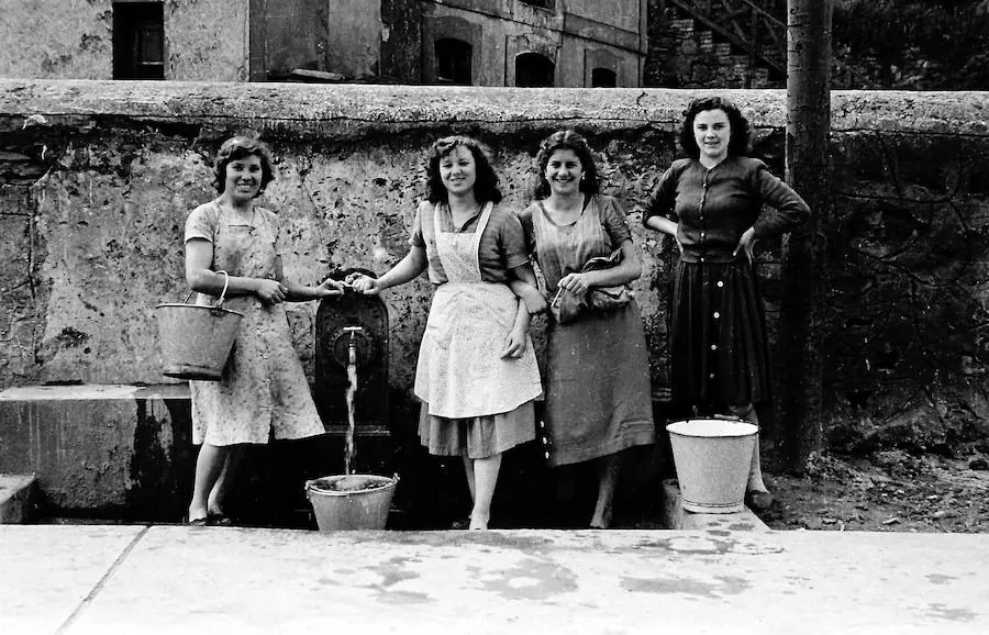 Mujeres cargando agua en la fuente de El Entrego.