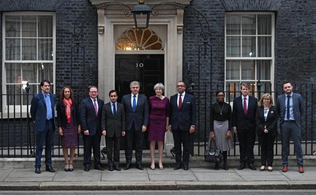 Theresa May posa ante el 10 de Downing Street junto a los cargos de su gobierno recién elegidos.