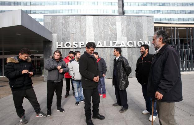 Familiares de Gonzalo Montoya Jiménez, con su padre José Carlos en el centro, ayer, en las puertas del HUCA. 