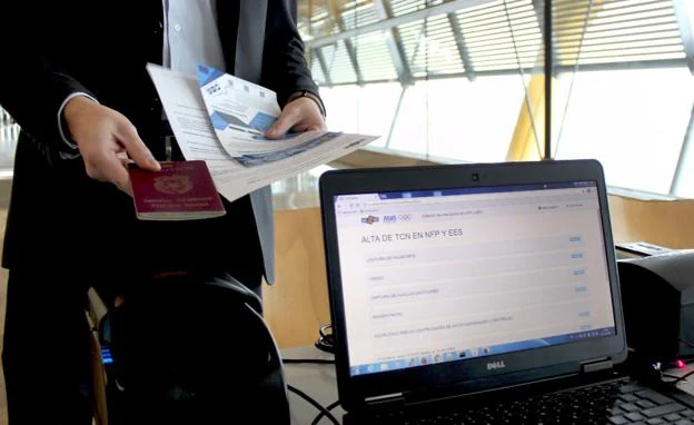 Un pasajero enseña el pasaporte en el aeropuerto de Barajas.