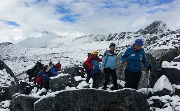 Imagen principal - Arriba, el equipo de Rosa Fernández sube al Chola Pass, camino de Zongla, durante su aventura por la región de Khumbu, el pasado noviembre. Abajo a la izquierda, las integrantes del Una a Una, en la cumbre del Gokyo, a 5.357 metros de altura.