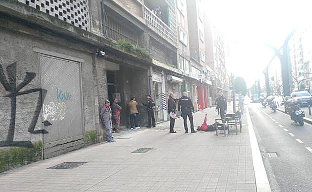 Uno de los heridos, tendido en la acera.