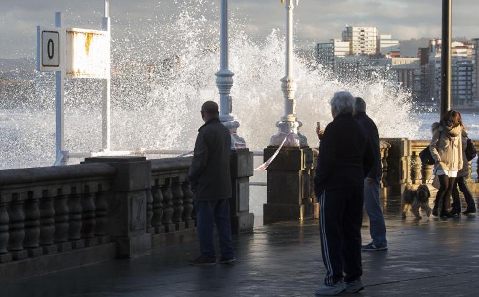 Las olas pillaron a algunas personas que se acercaron al paseo del Muro a hacer fotos.