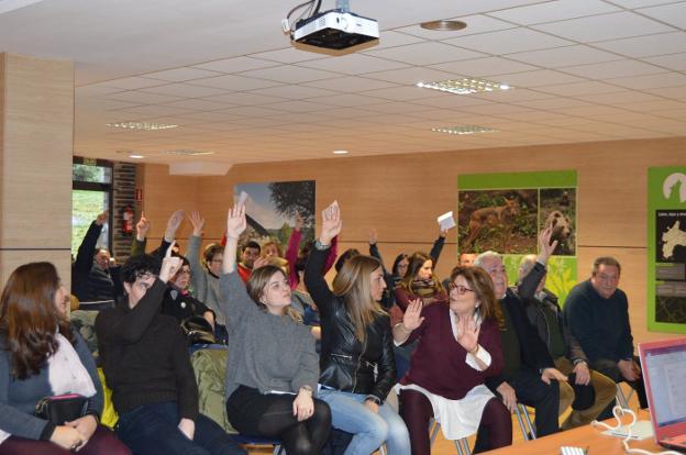 Los participantes en la asamblea alzan la mano para emitir su voto sobre las orquestas del Avellano. 