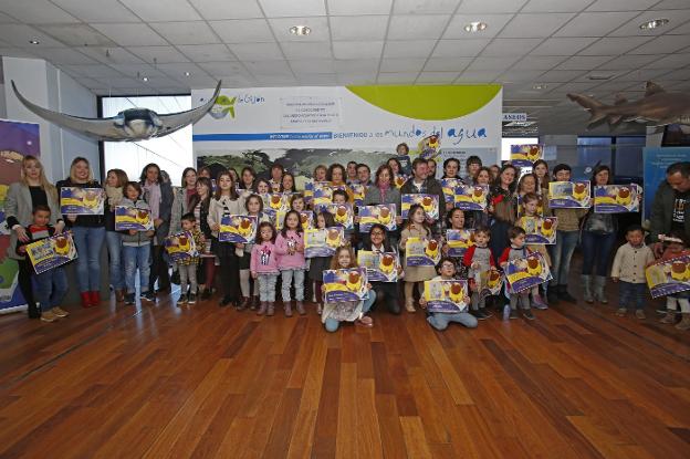 Los nuevos embajadores de L'Anguleru muestran su diploma en el vestíbulo del Acuario. 