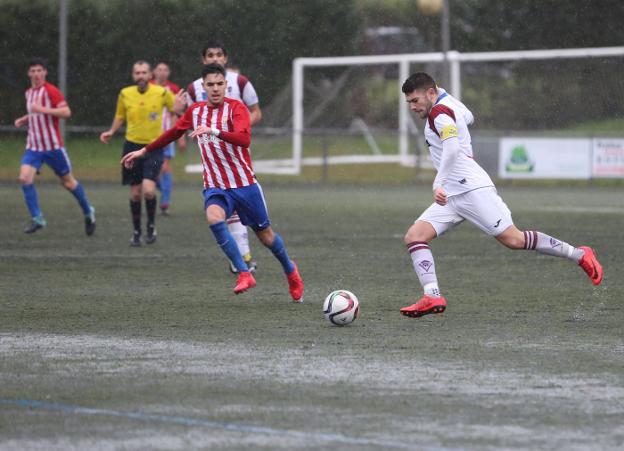 Sandoval, autor de los dos goles sportinguistas en Covadonga, presiona al capitán del conjunto local. 