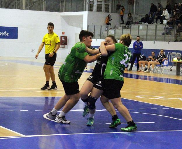 Dos jugadoras gallegas frenan a la local Lucía Álvarez en el partido disputado anoche. 