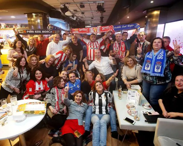 Aficionados del Real Oviedo y del Real Sporting de Gijón disfrutando del partido en el bar . 