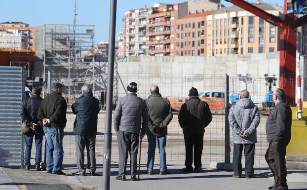 Un grupo de jubilados ante una obra en Logroño. 