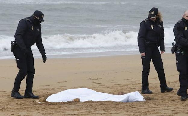 Imagen. Agentes de la Policía Nacional junto al cuerpo tendido sobre la arena.