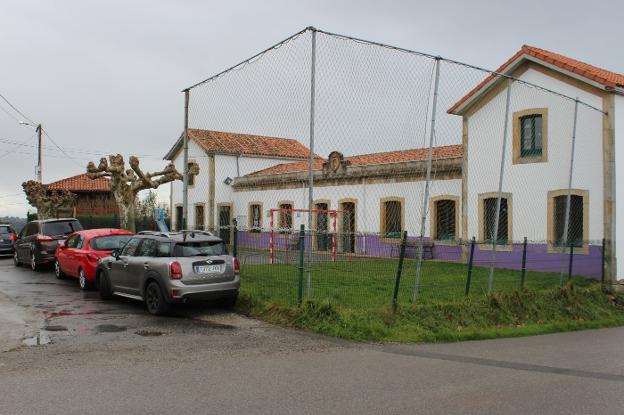 Varios coches aparcados junto a la escuela de Castiello. 