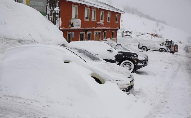 Imagen. La nieve cubre varios vehículos.