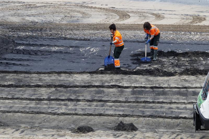 Operarios de Emulsa han iniciado las labores de limpieza de la mancha de carbón aparecida este domingo en la playa de San Lorenzo.