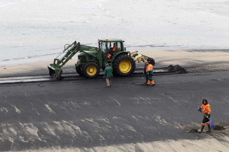 Operarios de Emulsa han iniciado las labores de limpieza de la mancha de carbón aparecida este domingo en la playa de San Lorenzo.