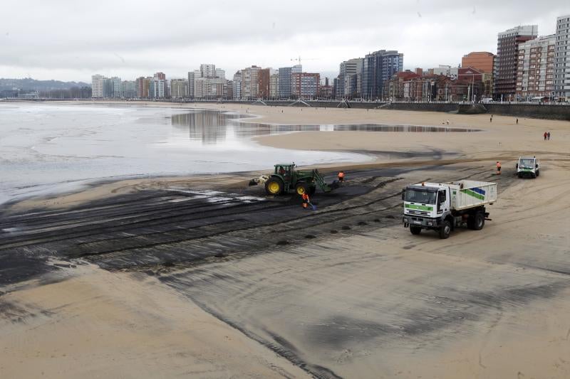 Operarios de Emulsa han iniciado las labores de limpieza de la mancha de carbón aparecida este domingo en la playa de San Lorenzo.