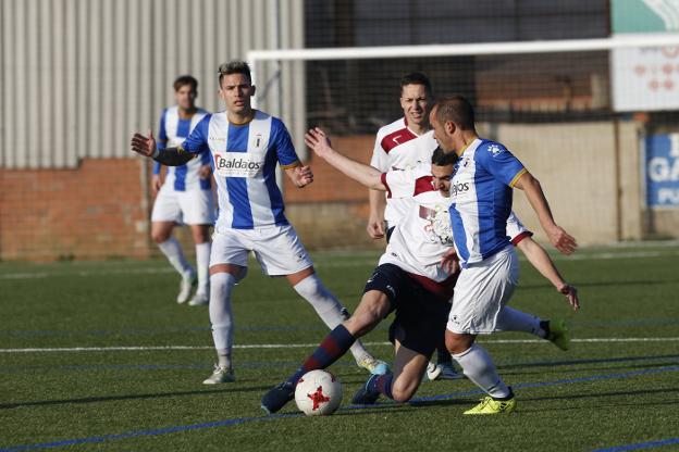 El fabril David gana un balón dividido a Carlinos. 