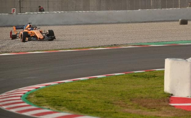 Fernando Alonso con su coche sin un nuemático. 