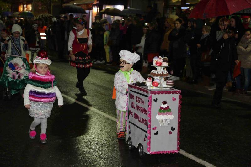 Pequeños y mayores se enmascararon en la localidad llanisca para recorrer las calles a ritmo de carnaval, a pesar de la lluvia.