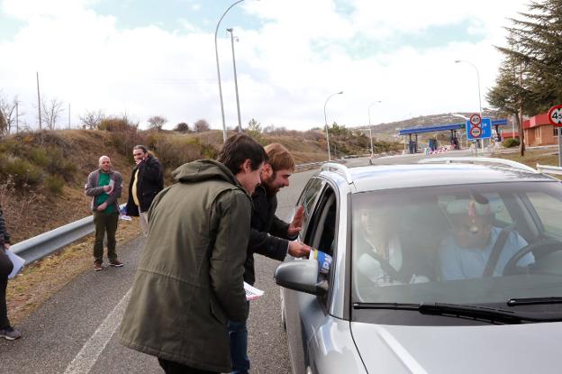 Segundo González y Daniel Ripa entregan folletos informativos a los conductores en el peaje de La Magdalena, en León. 