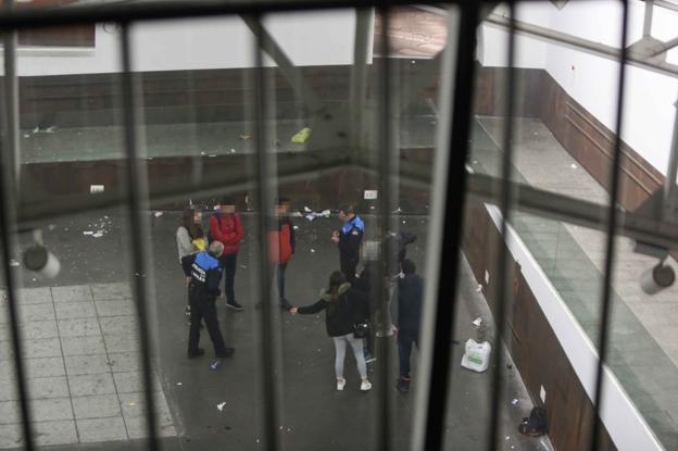 Agentes de la Policía Local dialogan con un grupo de jóvenes en el edificio. 