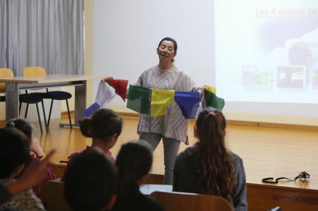 Rosa Fernández muestra y explica las banderas de plegaria. 