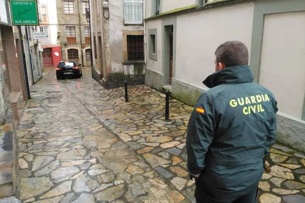 Efectivos de la Guardia Civil conducen a Javier Ledo a su vivienda, en el centro de Navia.