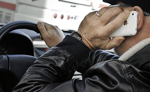 Un hombre habla por el teléfono móvil mientras conduce.