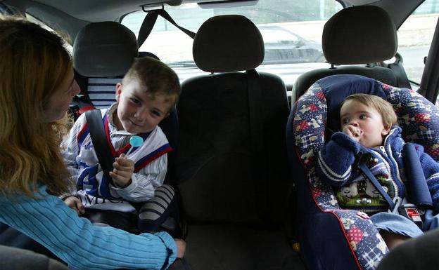 Imagen de archivo de tres niños en la parte trasera de un vehículo. 