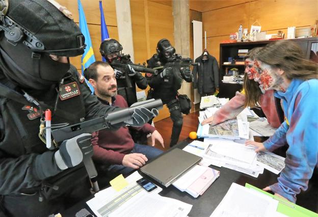 El alcalde de Siero, Ángel García, en su despacho, defendido por los militares del ataque de dos zombis. 