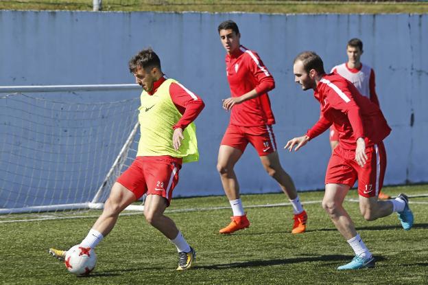 Los jugadores del Sporting B Traver, Pablo e Isma Aizpiri, durante un entrenamiento en Mareo. 