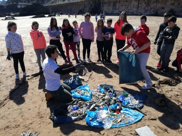 Varios de los alumnos, con los residuos recogidos en la playa. 