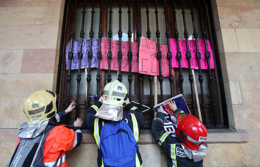 Bomberos de 37 parques de España se han concentrado en Oviedo bajo el lema 'Todos somos Eloy'. Es su respuesta a la sentencia por el fallecimiento del bombero en el incendio de Uría 58, en el que resultó herido su compañero Juan Carlos Fernández Grand, 'Cuni', que intervino en el Pleno municipal.