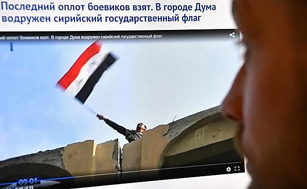 Espectador ruso observa la imagen de la bandera siria en Duma.