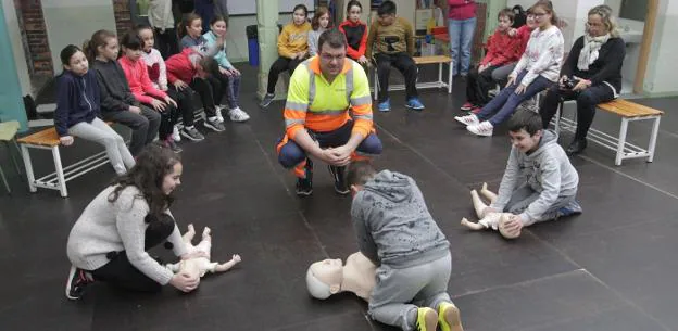 Los escolares de cuarto de Primaria practican la reanimación pulmonar en el patio, supervisados por Jorge Crespo. 