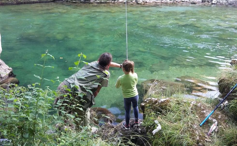 Óscar Rodríguez da instrucciones a su hija Sara, en el coto de Trescares, en el río que divide Asturias y Cantabria.