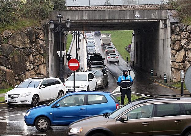 Un agente de movilidad controla el tráfico en la rotonda de Luis Oliver. Al fondo, el acceso a Ciudad Naranco.