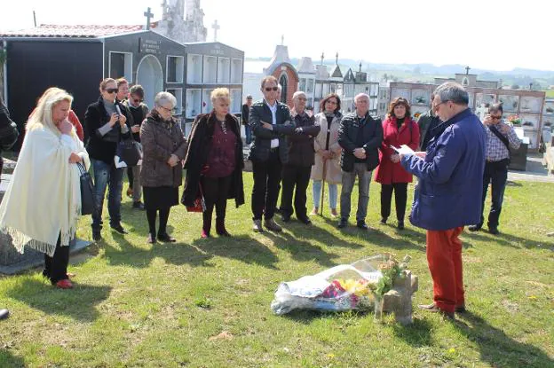 Alejandro Ferrer lee un poema ante la fosa y el ramo de flores de las familias. 