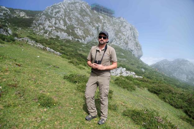 El director de la Fundación Para la Conservación del Quebrantahuesos, Gerardo Báguena, con la plataforma de liberación de ejemplares instalada en los Picos de Europa a sus espaldas. 