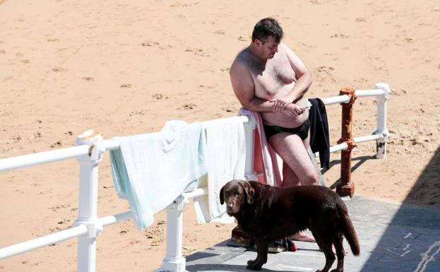 Un bañista en la playa de San Lorenzo de Gijón, disfrutando del buen tiempo. 