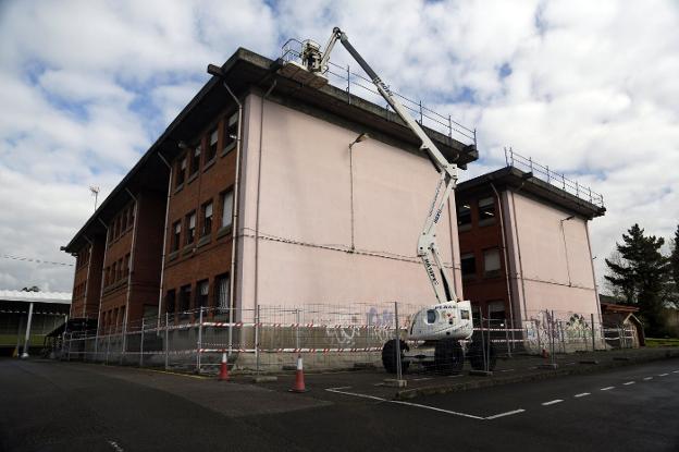 Un operario trabaja en la reparación del tejado del Colegio Público Lugo de Llanera. 