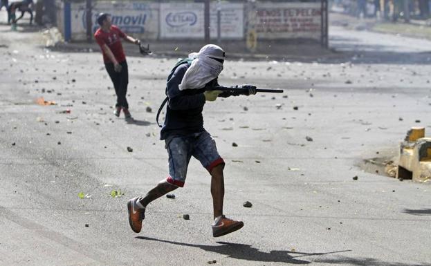 Un nicaragüense se prepara para disparar con un arma casera. 