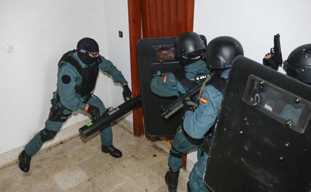 Los miembros de la URO derriban una puerta para acceder al piso.