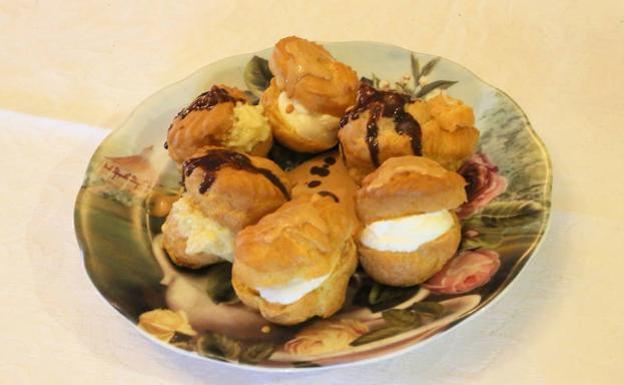 Profiteroles rellenos de nata, con salsa de caramelo y crema de vainilla