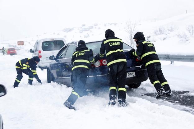 Integrantes de la UME empujan un coche en la AP-6 en enero. 