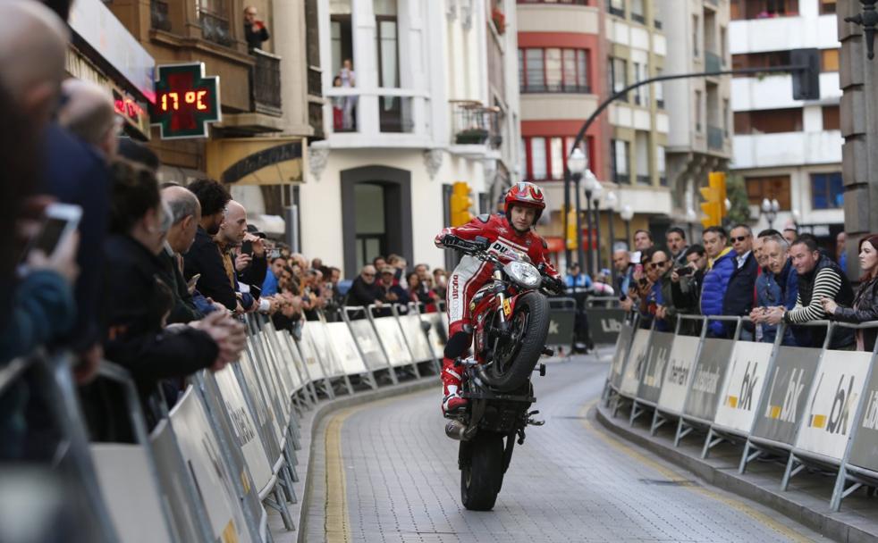 El piloto Emilio Zamora realiza acrobacias sobre su moto por la calle del Carmen, en Gijón. 