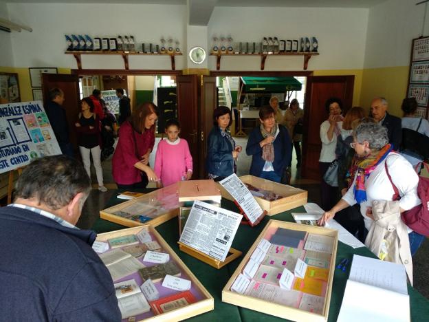 Antiguos alumnos y actuales visitan la exposición de documentos antiguos del instituto. 