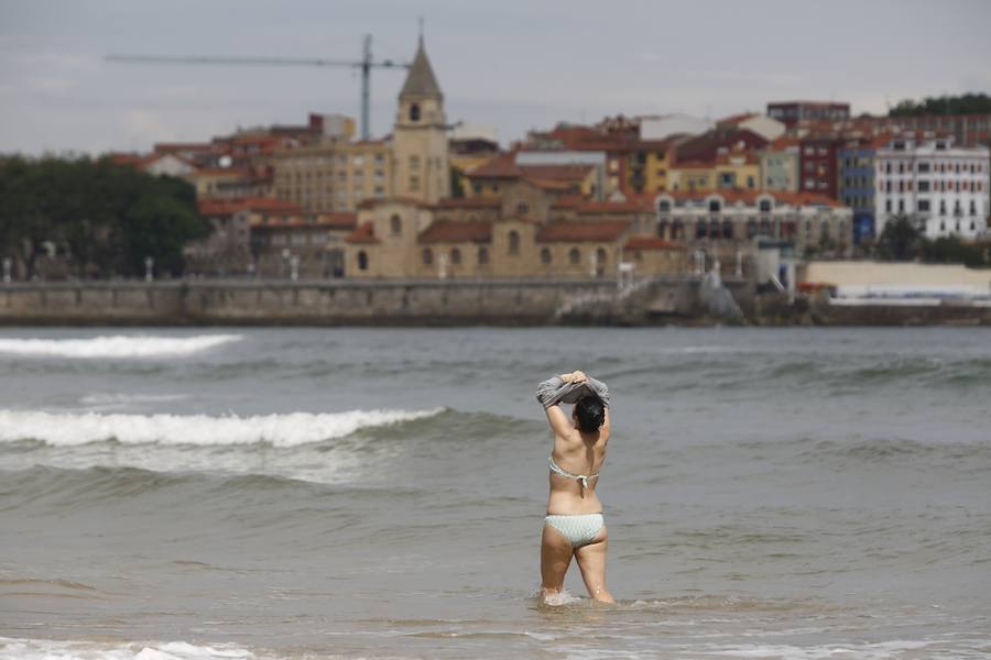 Tras dos días cerrada por vertidos, el Ayuntamiento de Gijón ha izado la bandera verde en la playa de San Lorenzo en un día de tiempo agradable que ha animado a numerosos vecinos y visitantes a acercarse al arenal.