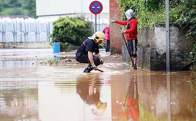 Imagen. Un bombero intenta desatascar una alcantarilla en la calle San Francisco.