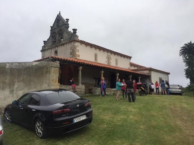 Un grupo de vecinos congregados en el exterior de la iglesia de San Félix, en Oles. 