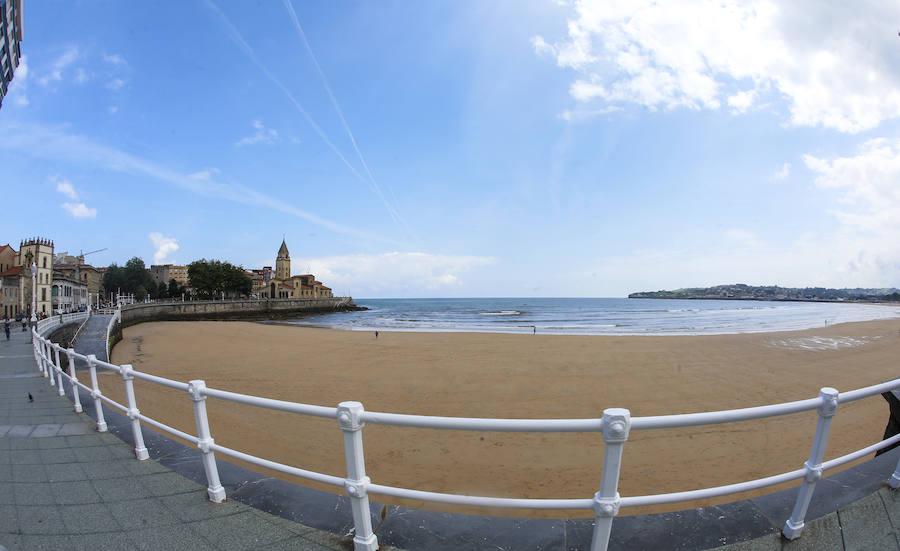 Las banderas amarilla y verde que luce la playa y la buena temperatura ya ha animado a algunas personas a pegarse un baño en el Cantábrico. 